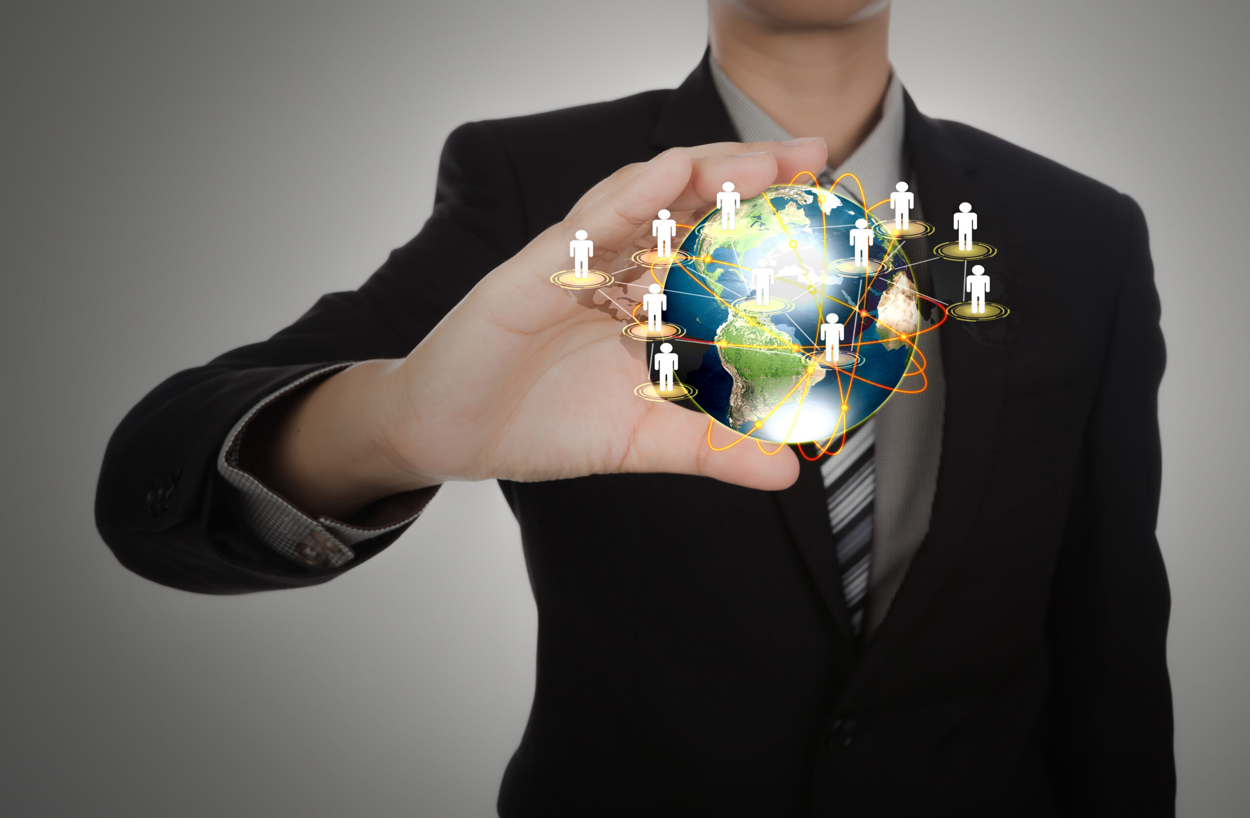 Business man holding the small world in his hands against white